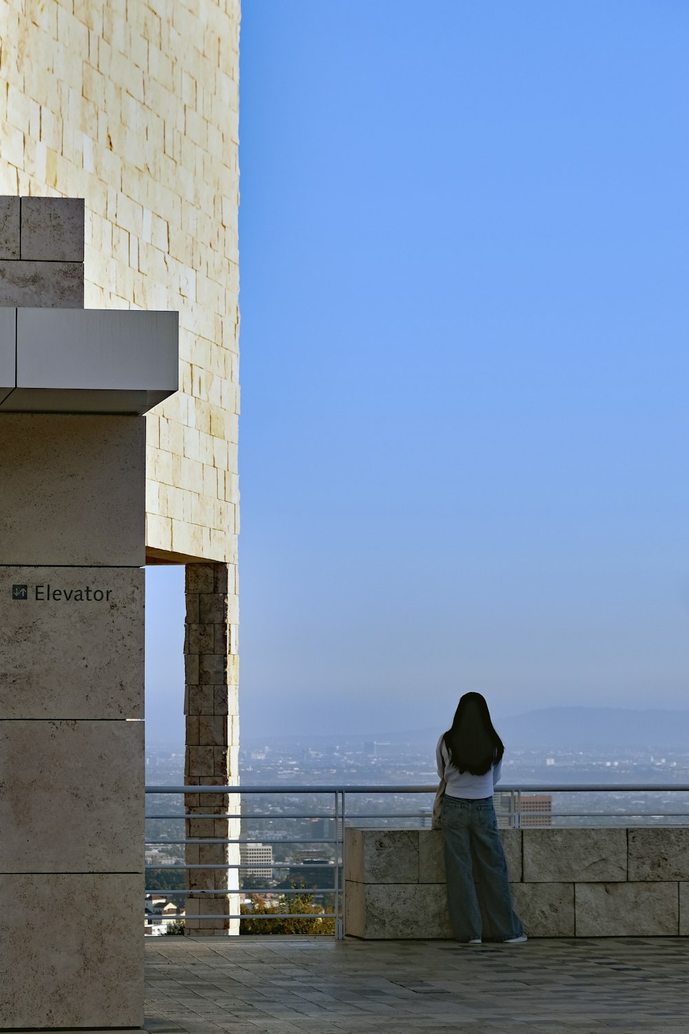 a woman standing on a balcony next to a building