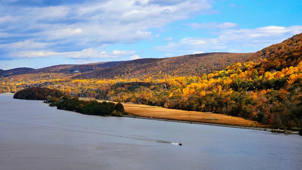 a boat traveling down a river surrounded by mountains