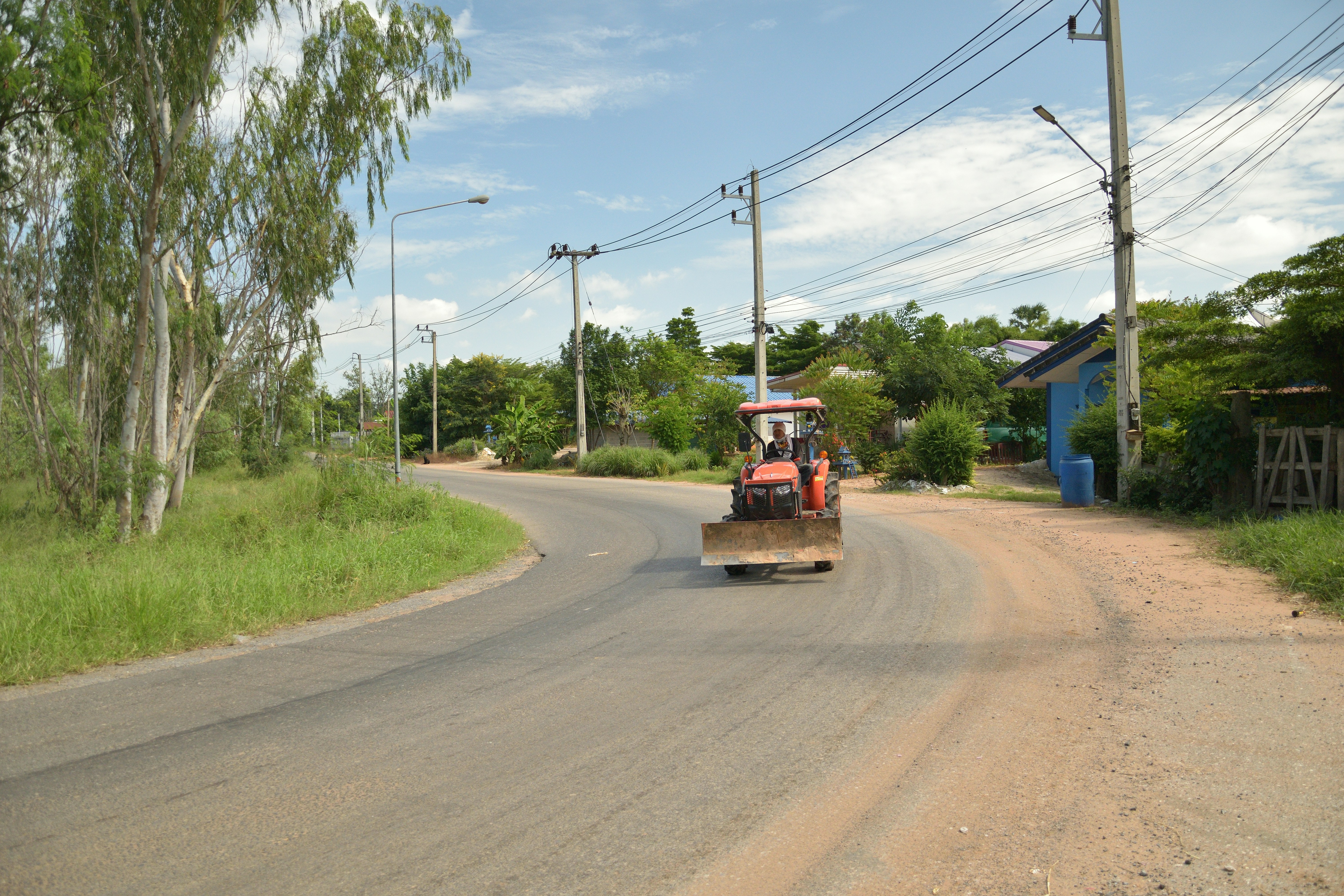 a tractor is driving down a rural road