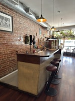 Cozy café corner with exposed brick walls and stylish pendant lights.
