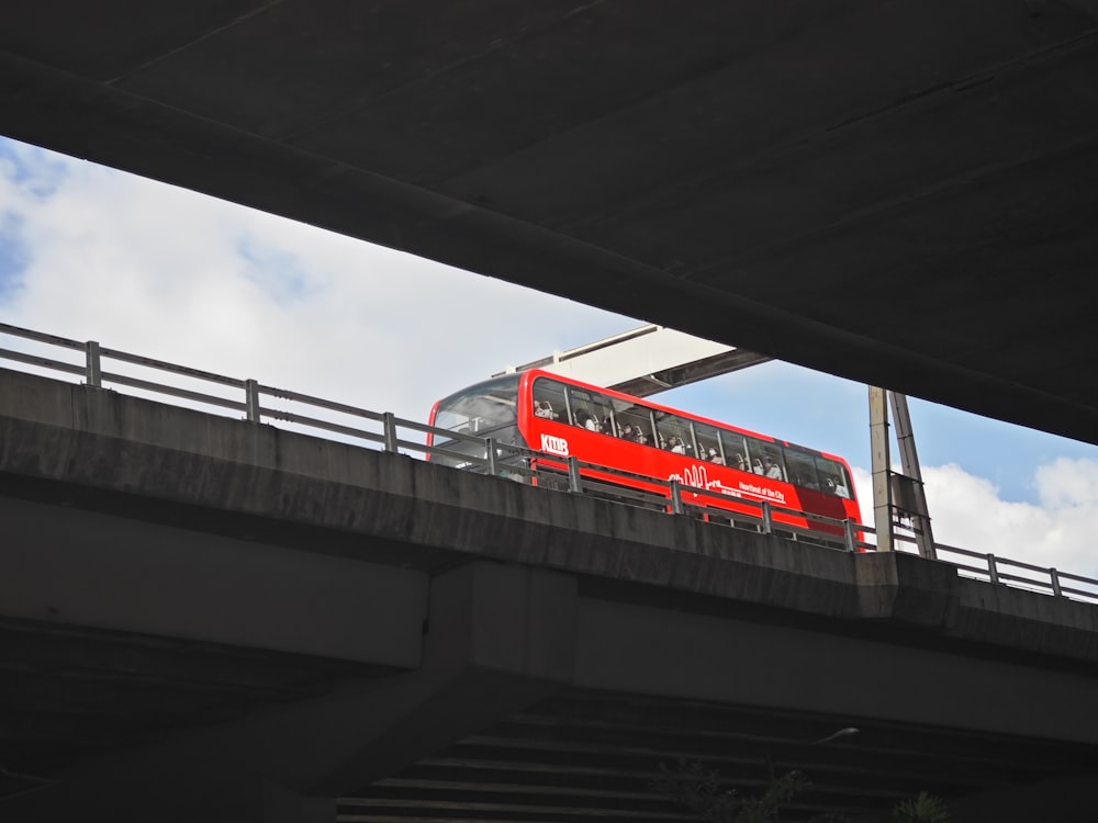 a red double decker bus traveling over a bridge