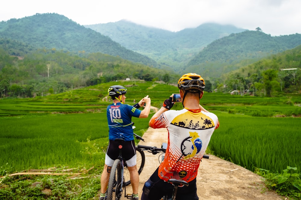 a couple of people on bikes on a dirt road