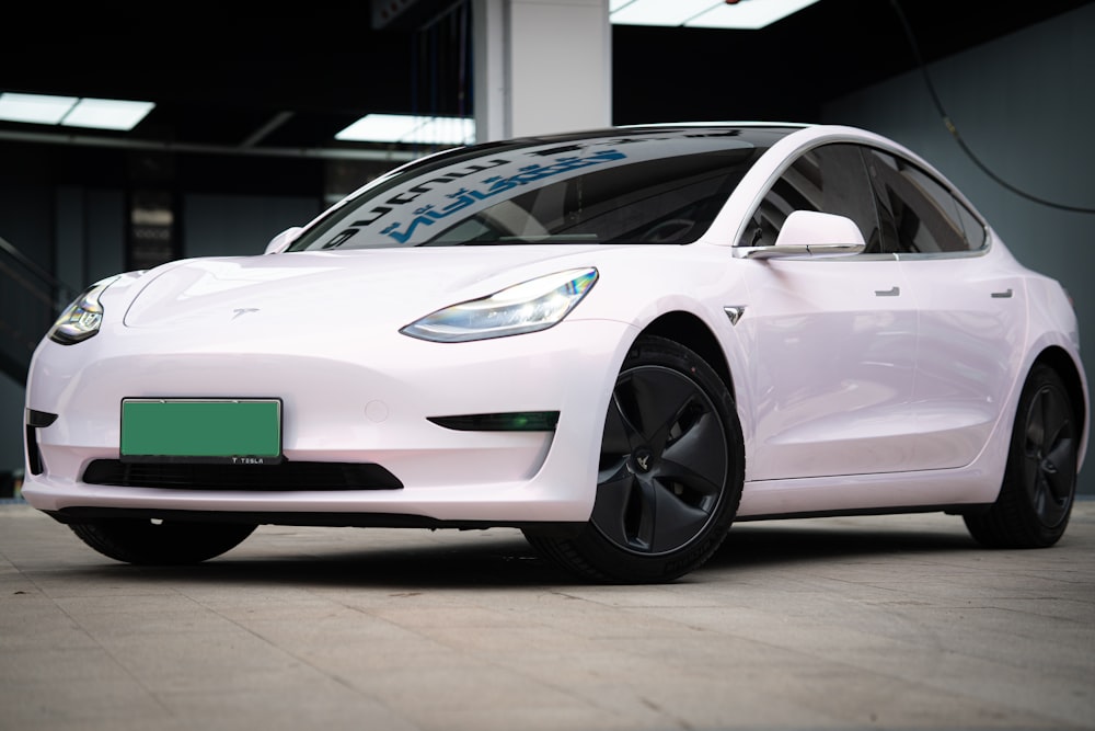 a white electric car parked in a garage