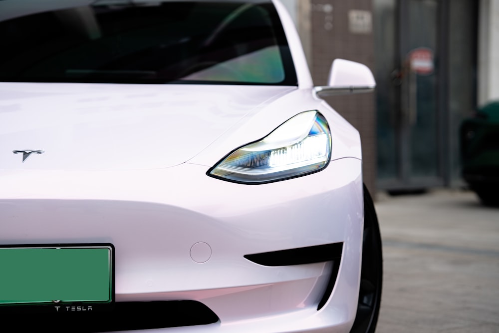 a white tesla car parked on a city street