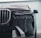 A close-up view of the front of a luxury car showcasing a sleek black grille and modern LED headlights. The metallic elements give a sense of opulence and sophistication, with smooth contours and reflective surfaces.