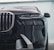 A close-up view of the front of a luxury car showcasing a sleek black grille and modern LED headlights. The metallic elements give a sense of opulence and sophistication, with smooth contours and reflective surfaces.