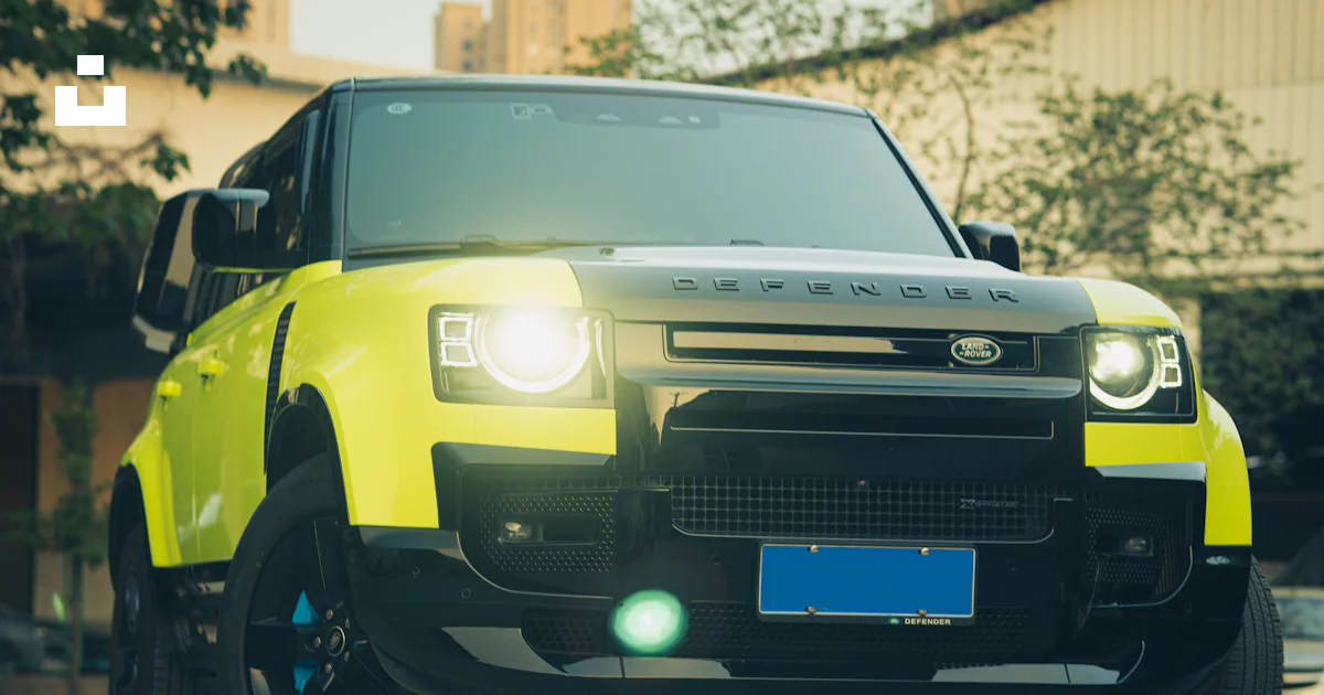 A bright yellow land rover is parked in a parking lot photo – Free ...