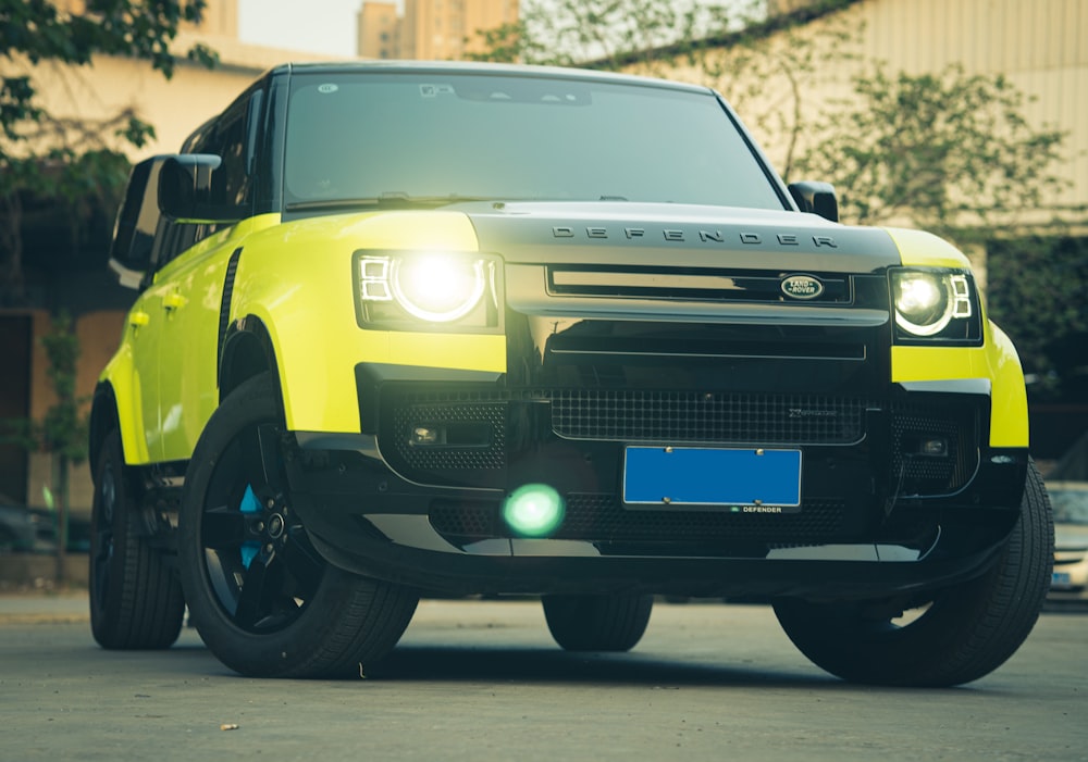 a bright yellow land rover is parked in a parking lot