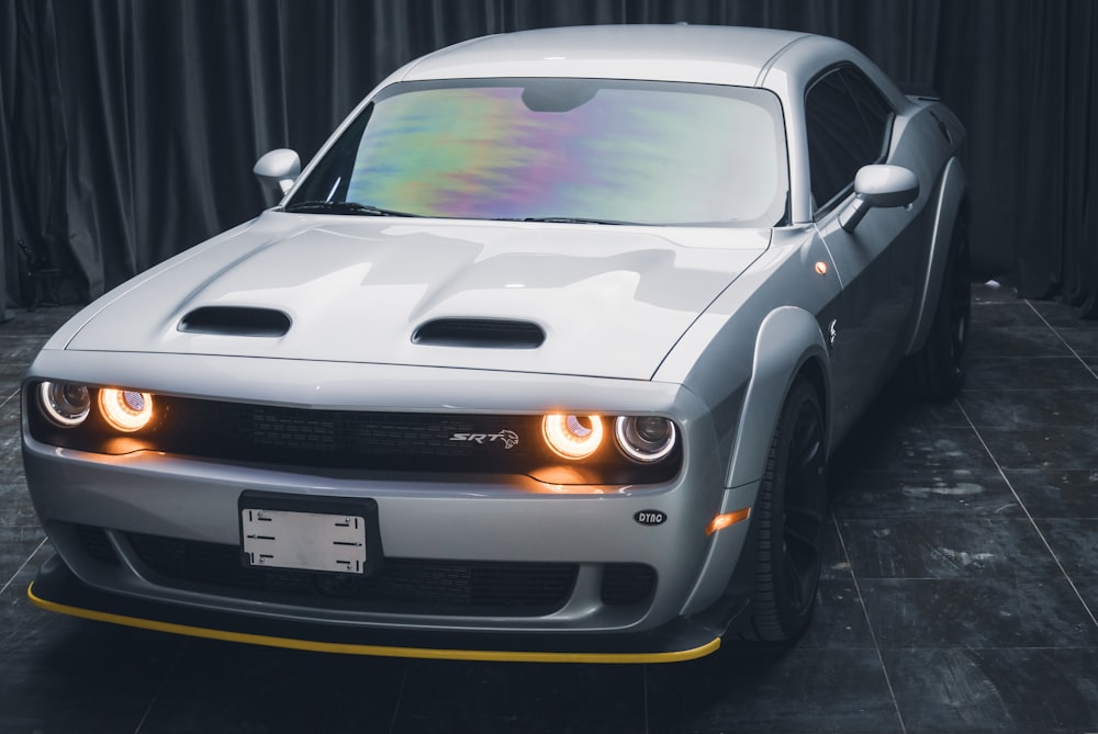 a white sports car with a rainbow painted hood