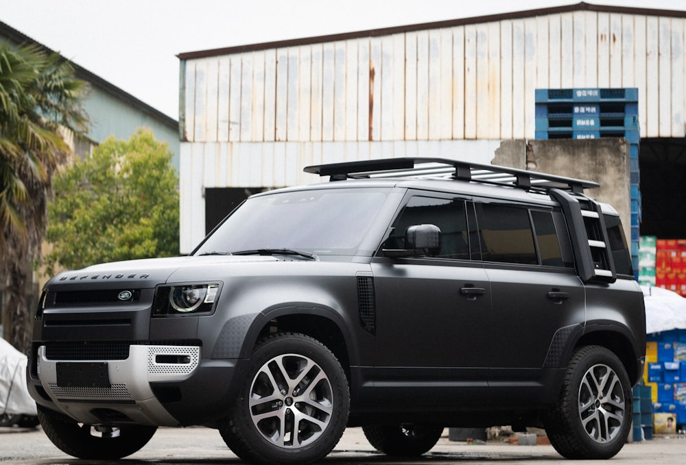 a grey land rover parked in front of a building