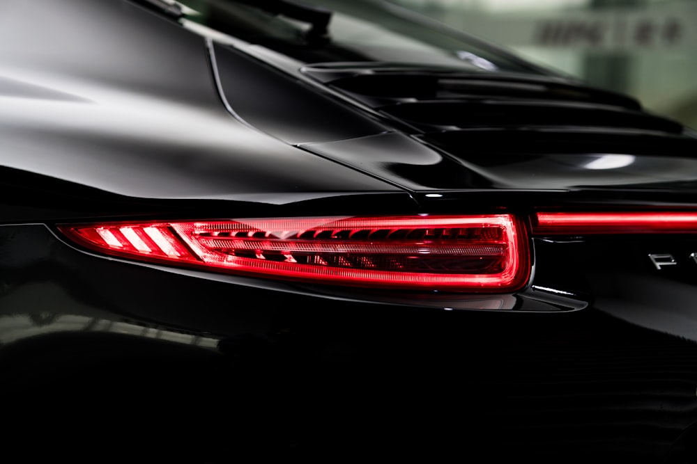 the tail lights of a black sports car