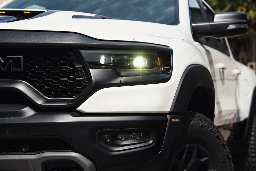 a close up of a white truck with its lights on