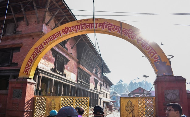 A warm, inviting photo of the Arya Samaj Greater Noida temple entrance with soft sunlight.