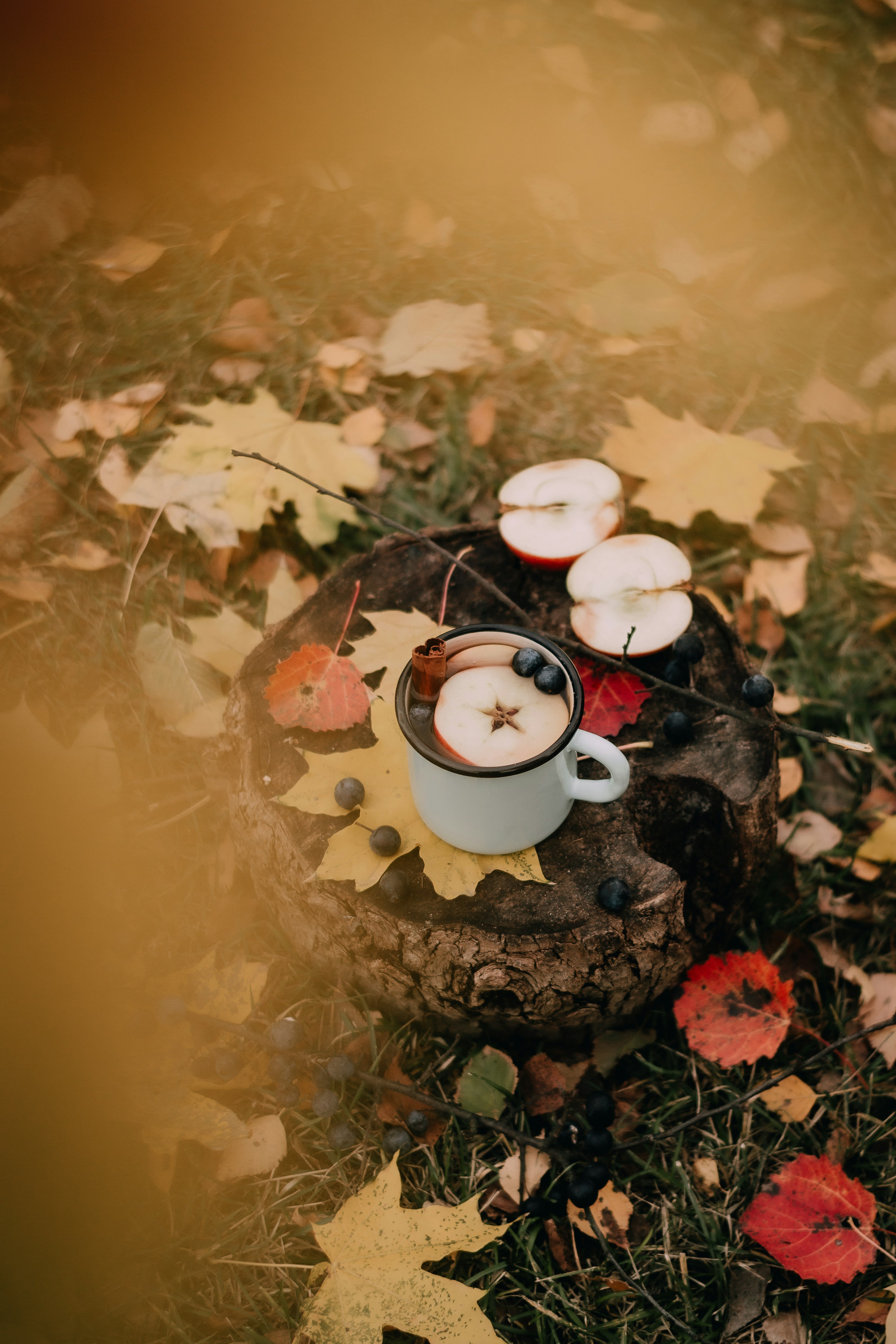 a cup of coffee and some candles on some leaves