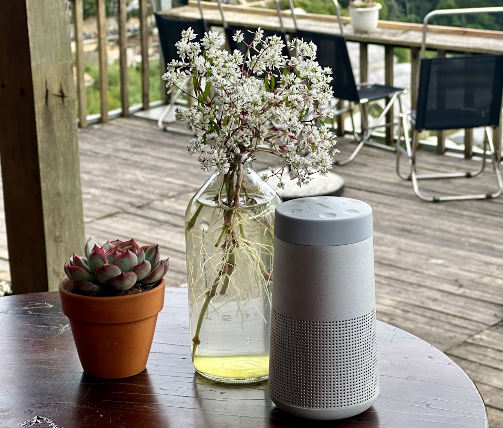 a table with a vase of flowers and a speaker on it