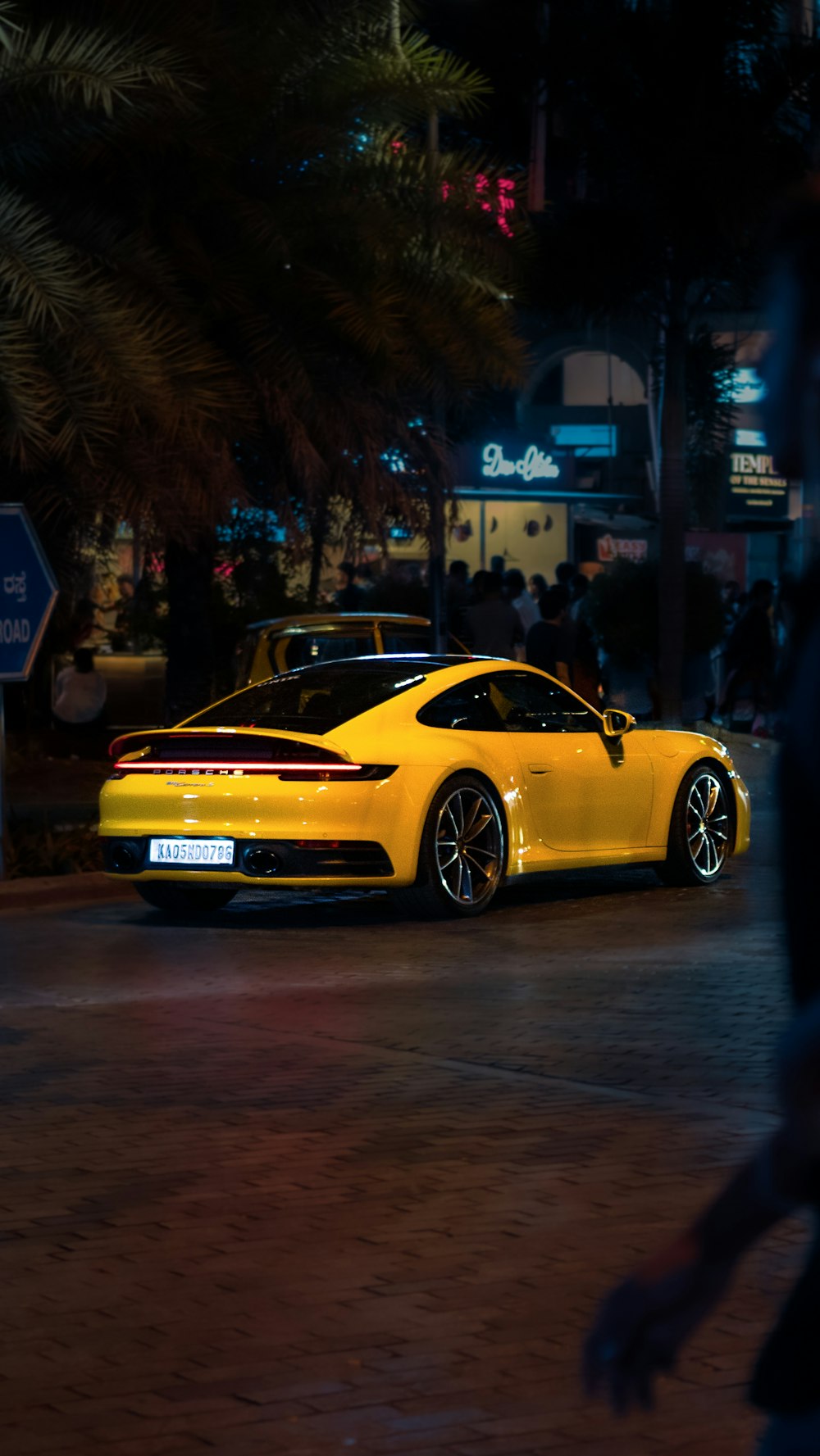 a yellow sports car parked on the side of the road