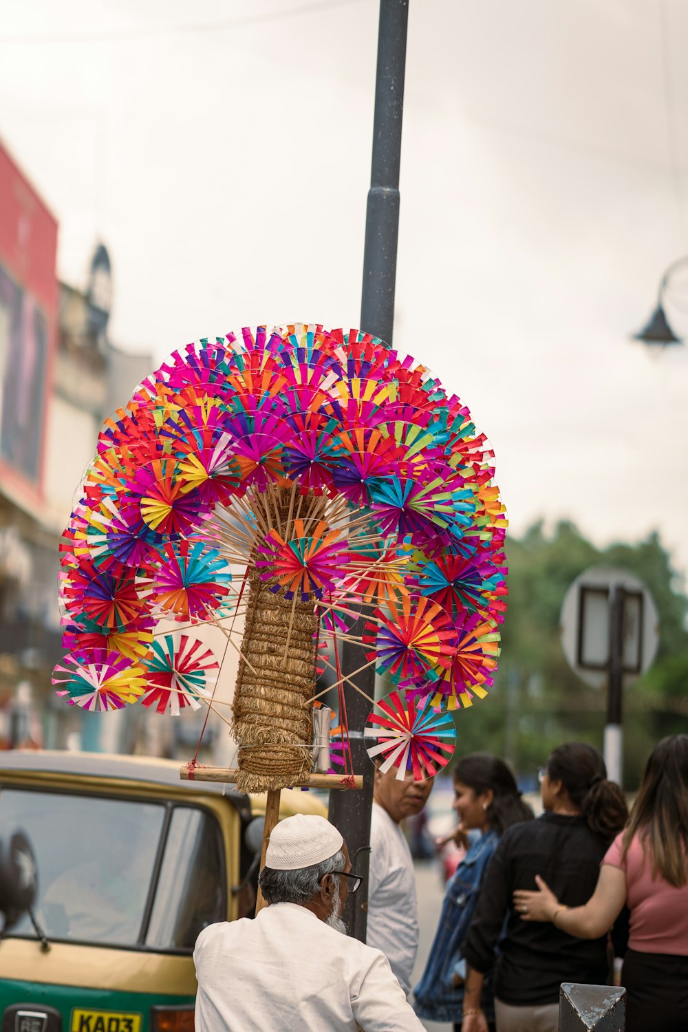 a man standing next to a pole with a colorful umbrella