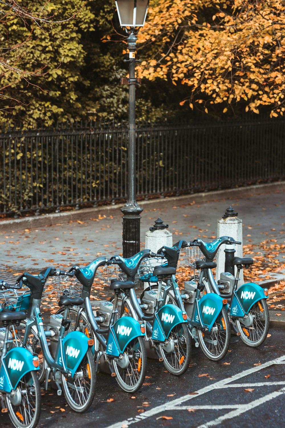 a row of bicycles parked next to a lamp post