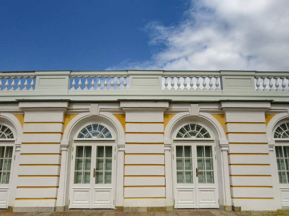 a white and yellow building with windows and balconies