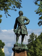 A grand bronze statue of a historical figure standing proudly in an open plaza.