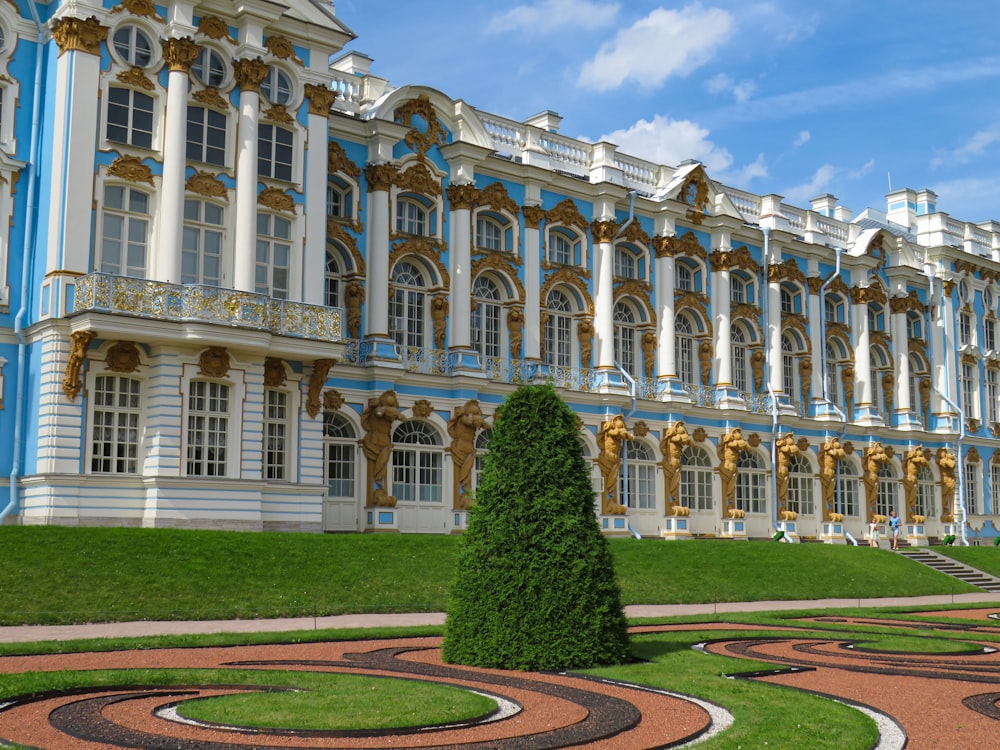 a large blue and white building sitting on top of a lush green field