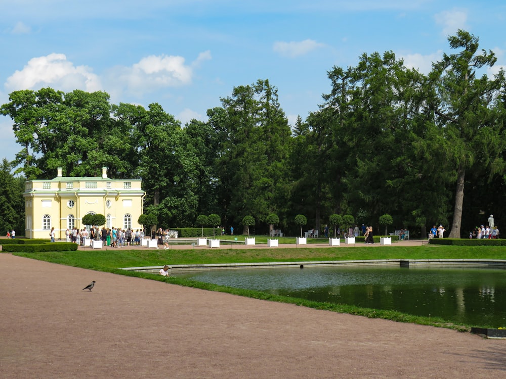 a large yellow building with a pond in front of it