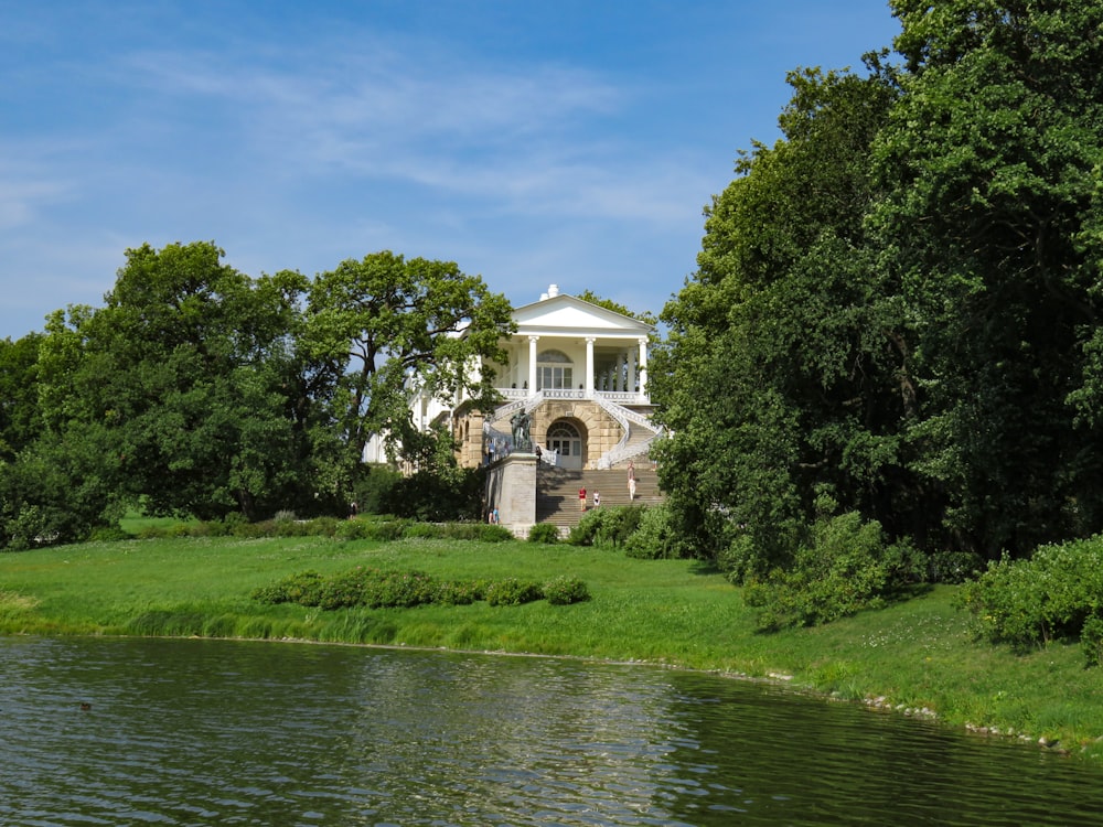 a large white house sitting on top of a lush green field