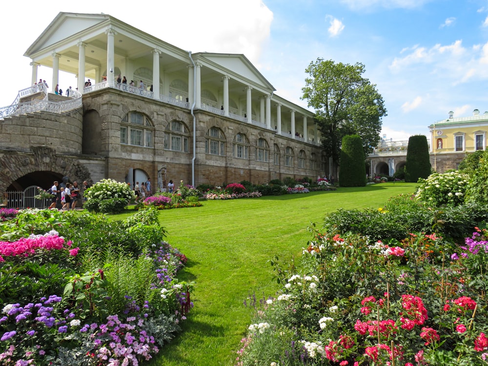 a large building with many flowers in front of it