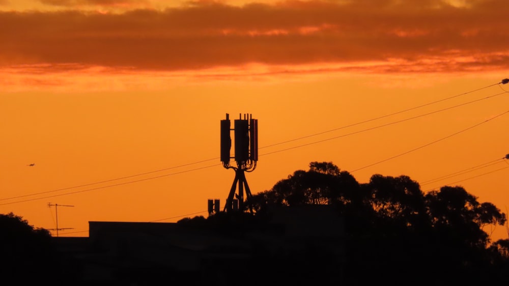 a sunset with a cell phone tower in the foreground