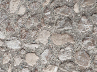 Close-up of stamped concrete patio with a natural stone pattern in warm earth tones.