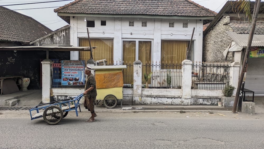 a man pushing a cart down a street