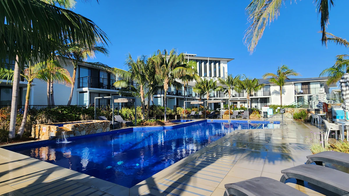Resort swimming pool surrounded by palm trees