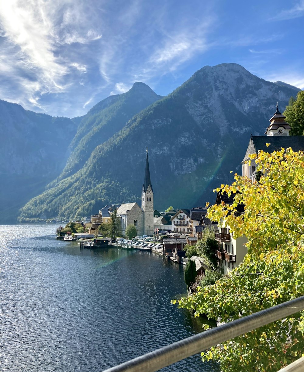 a scenic view of a town on a lake with mountains in the background