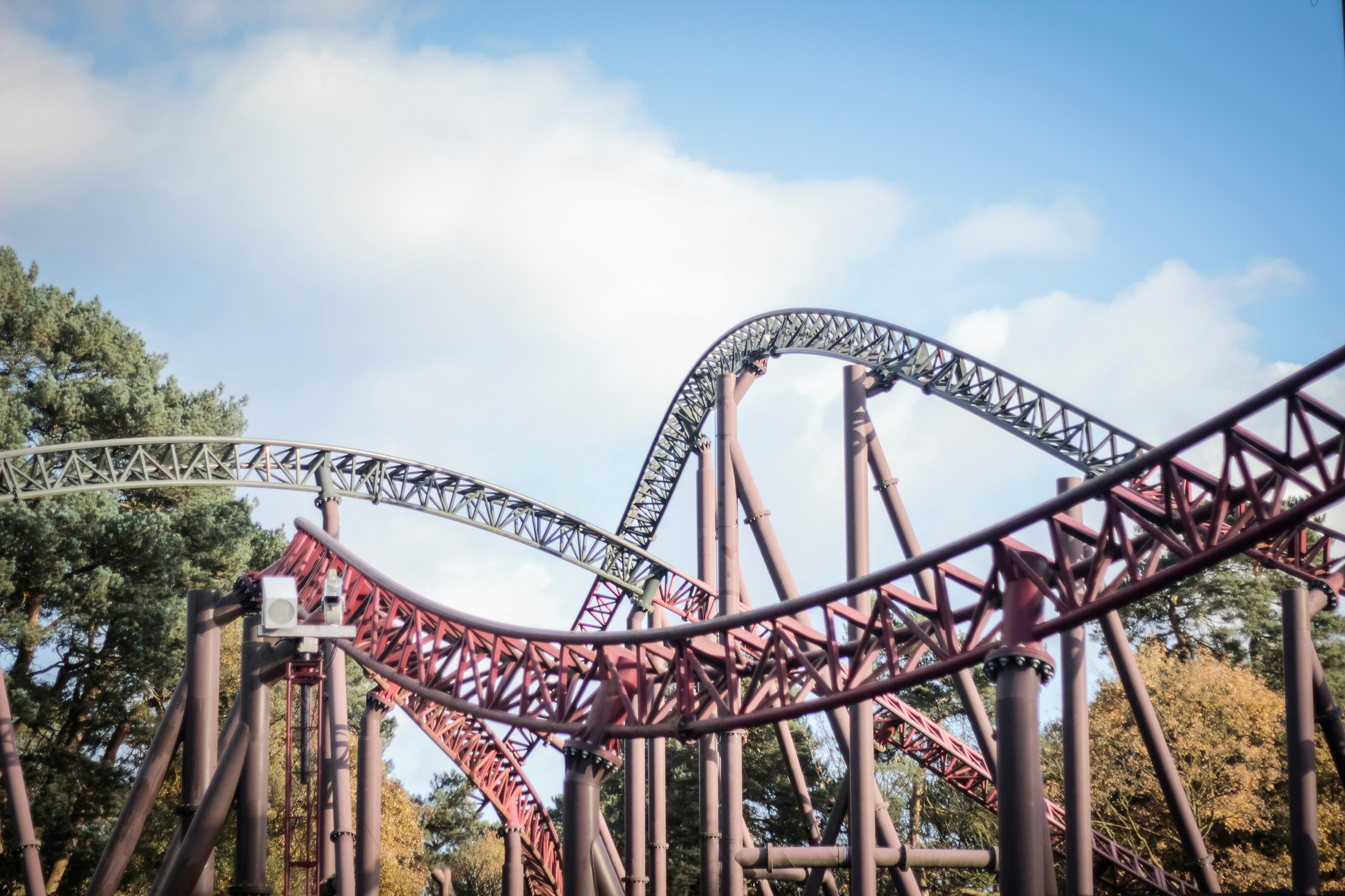 a roller coaster going down a hill on a cloudy day, 