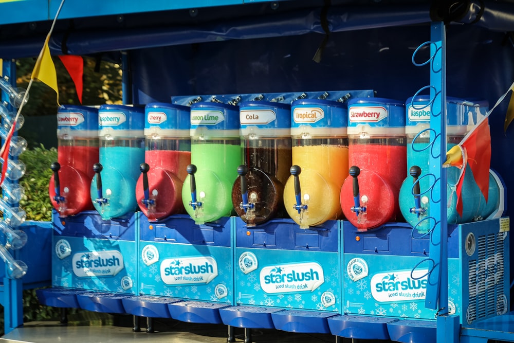 a row of colorful cups sitting on top of a blue cart