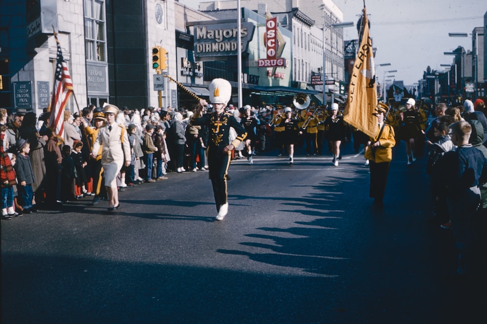 a parade with a marching band marching down the street