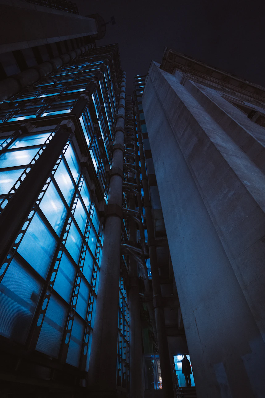 Night-lit glass towers seen from below — Andrea De Santis on Unsplash