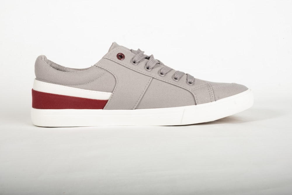 a gray and red sneaker with a white sole