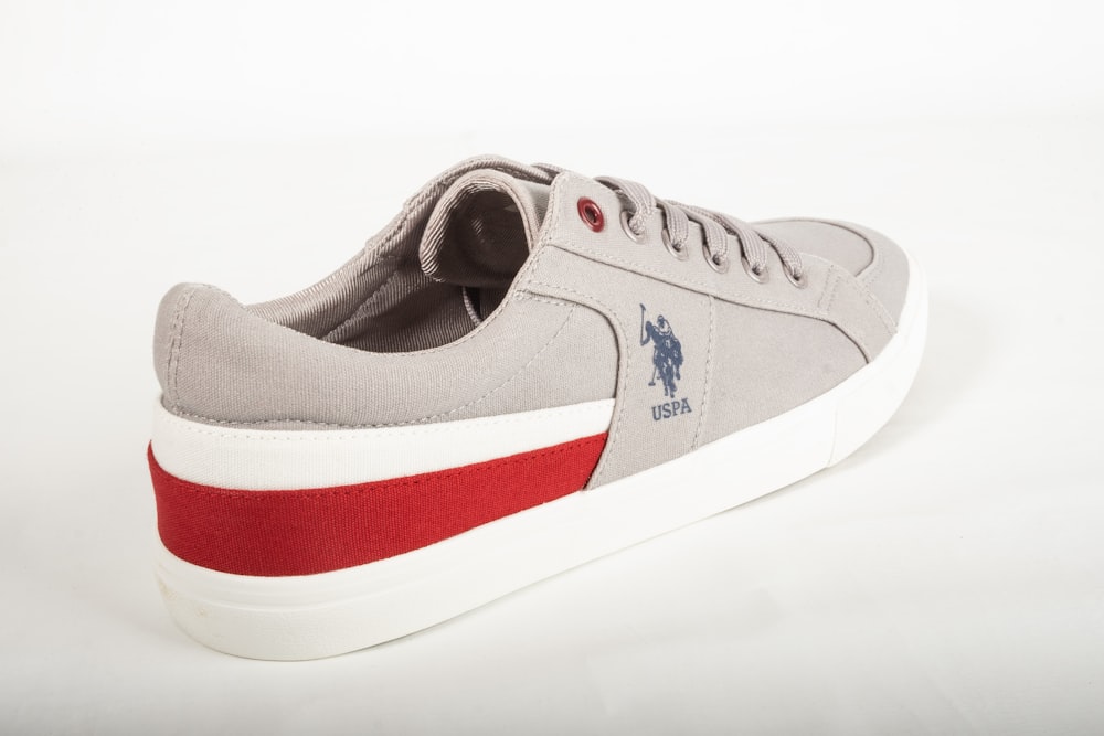a gray and red sneaker with a white sole