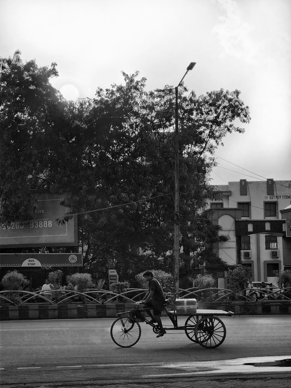 a person riding a bike with a cart attached to it