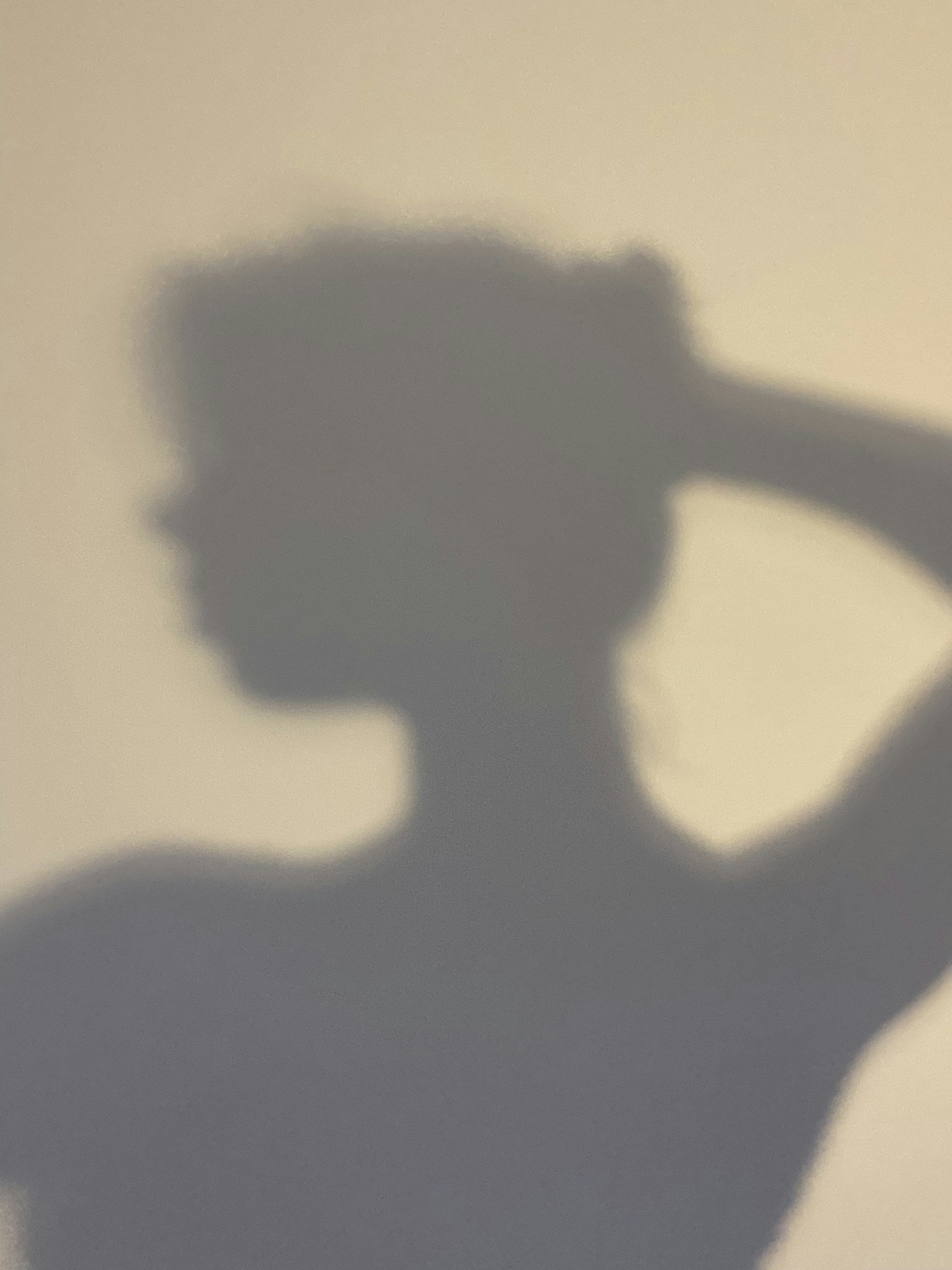 a shadow of a woman holding a tennis racquet