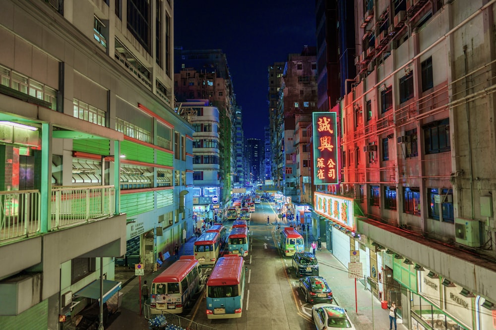 a city street filled with lots of traffic next to tall buildings