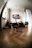 A cozy living room scene with a cat watching a tablet screen showing a playful cat video.