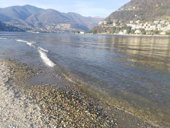 Tranquil lakeside view with gentle waves and distant hills.