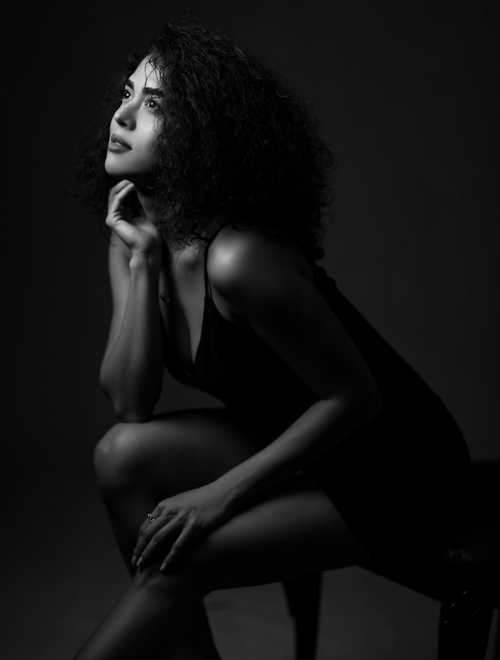 a black and white photo of a woman sitting on a chair