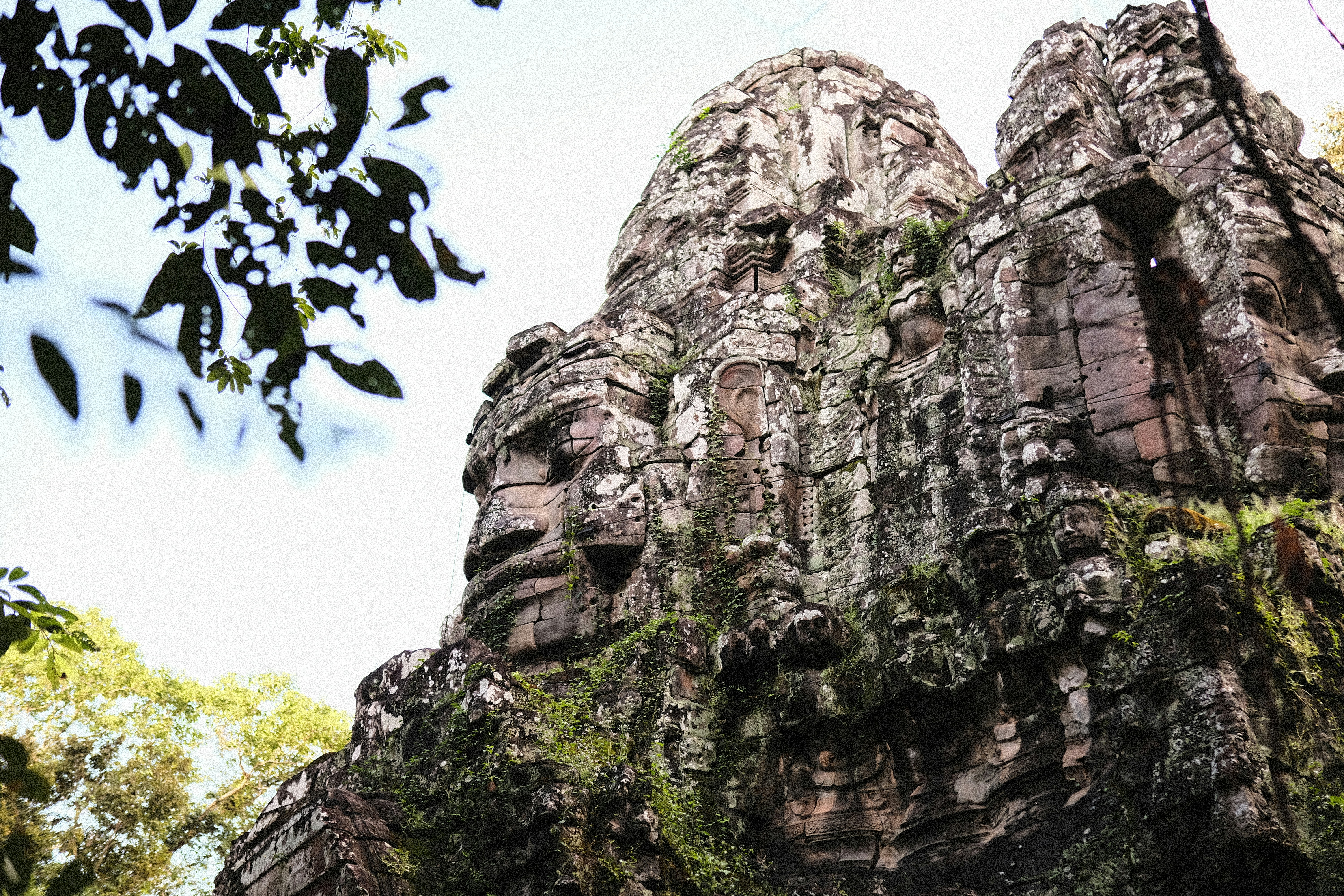 a group of faces on the side of a rock formation, Khmer Ancient Gate.