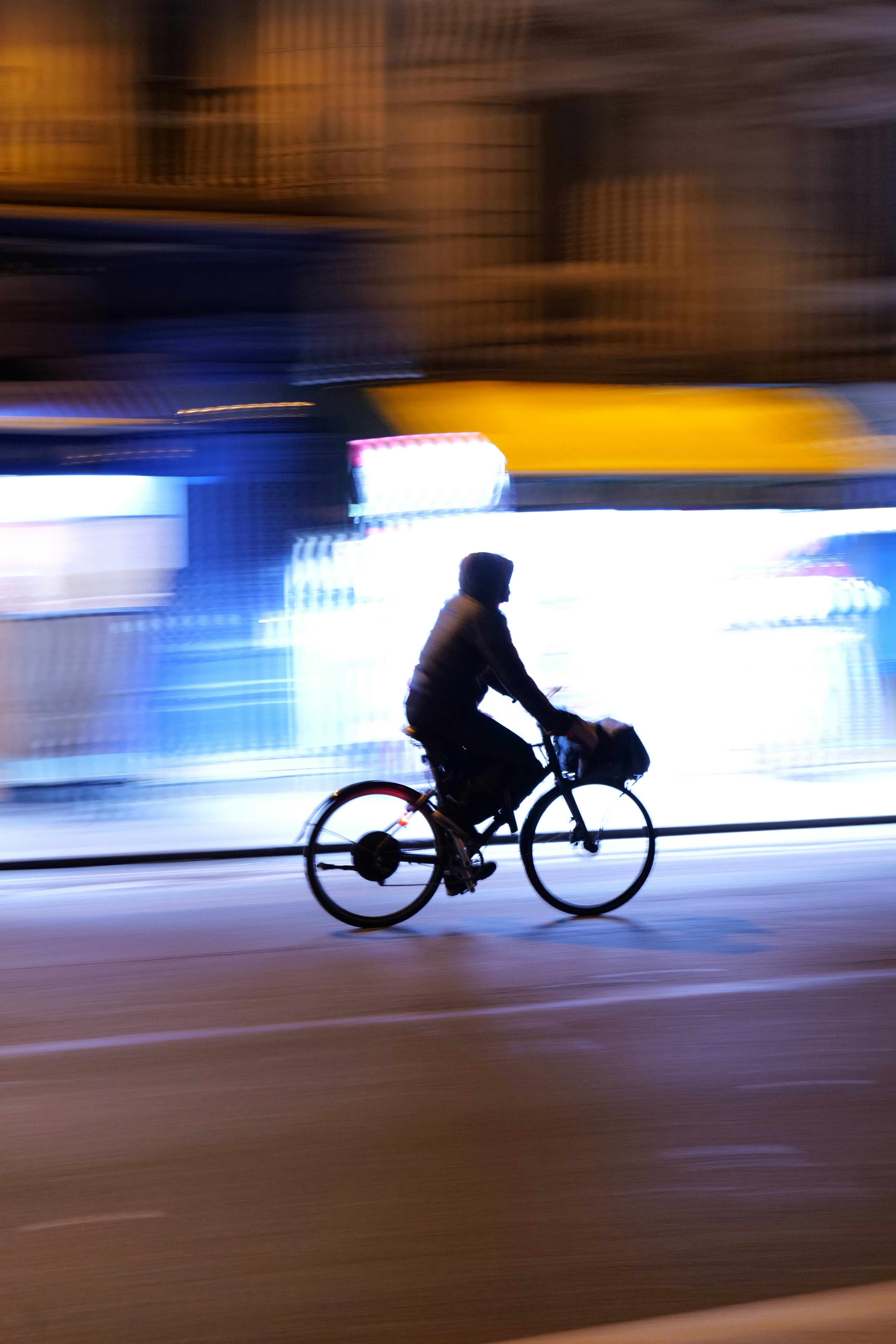 a man riding a bike down a street at night