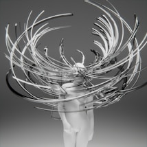 A minimalistic white humanoid figure is surrounded by an intricate array of swirling, elongated metallic and transparent structures, creating a dynamic and abstract visual effect. The background is a plain gradient gray, which enhances the focus on the central figure and the surrounding elements.