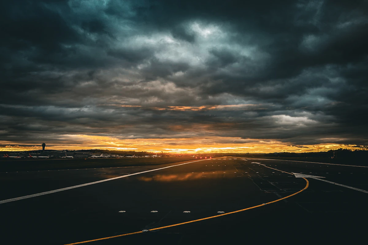 Rain streaking across an airport terminal window as a plane waits on the tarmac