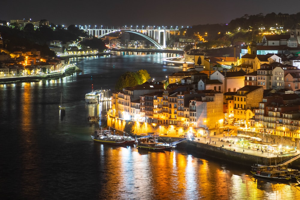 Una vista nocturna de una ciudad con un puente al fondo